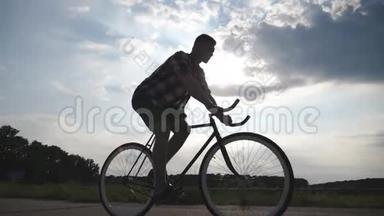 年轻男子骑着老式自行<strong>车</strong>的<strong>剪影</strong>，背景是美丽的天空。 骑自行<strong>车</strong>的人
